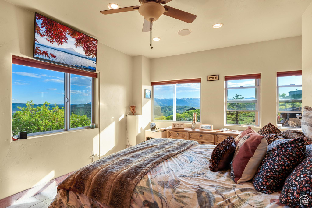 Bedroom featuring ceiling fan and multiple windows