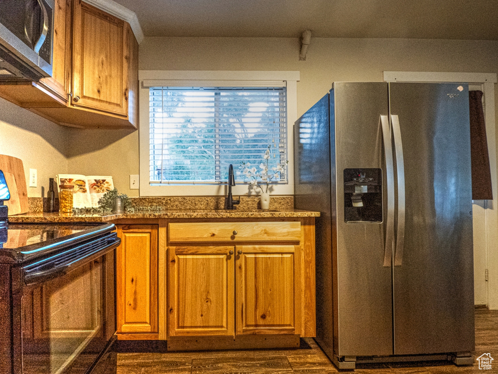 Kitchen with stainless steel appliances and dark hardwood / wood-style floors