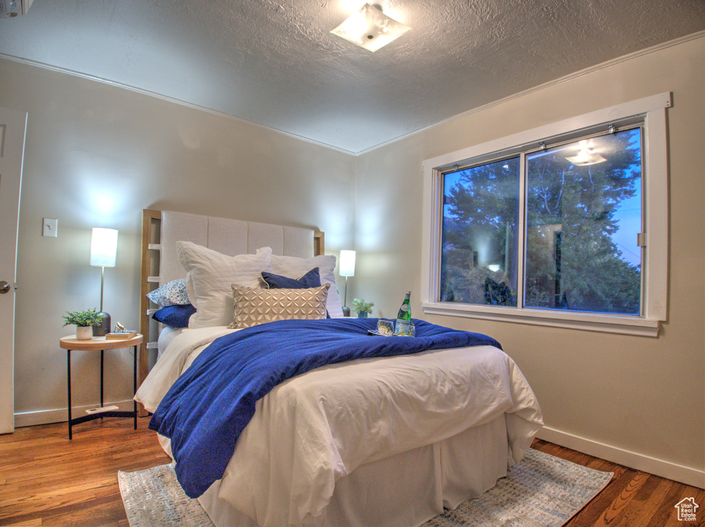 Bedroom featuring a textured ceiling and hardwood / wood-style floors