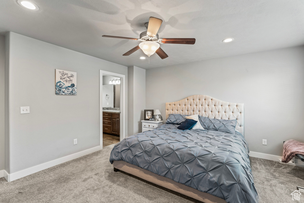 Bedroom with ensuite bathroom, carpet, and ceiling fan