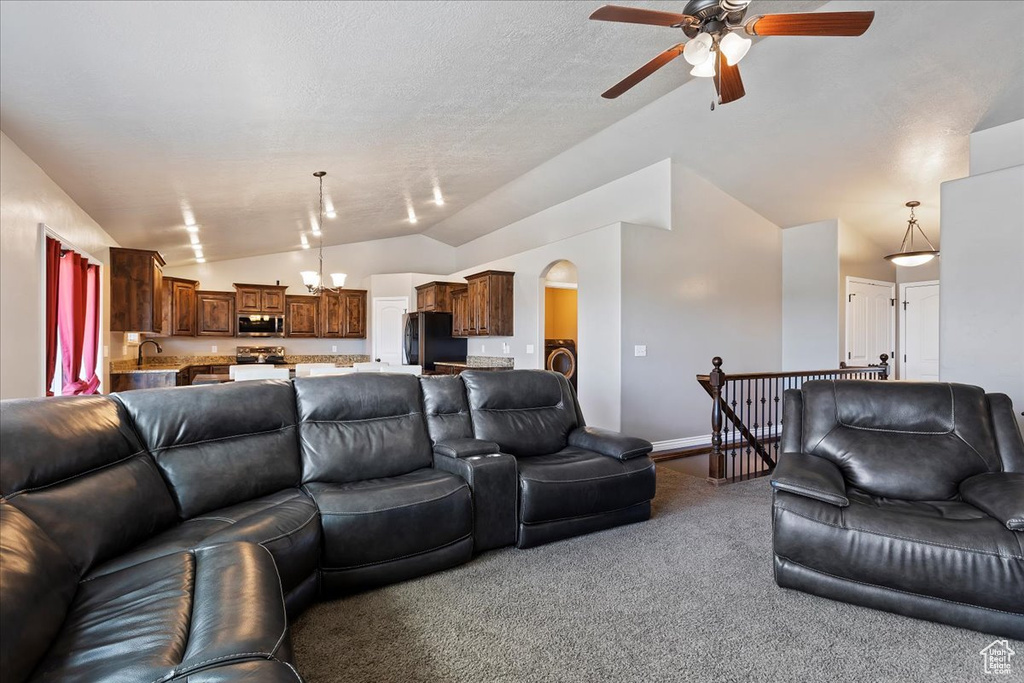 Carpeted living room with sink, lofted ceiling, ceiling fan, and washer / clothes dryer