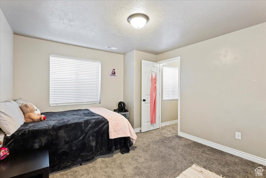 Bedroom featuring a textured ceiling and carpet flooring