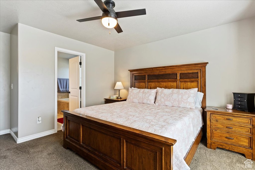 Bedroom featuring ceiling fan, connected bathroom, and carpet flooring