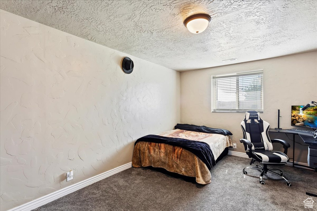 Bedroom featuring a textured ceiling and carpet floors