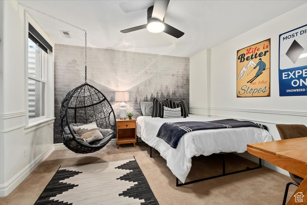 Bedroom featuring carpet, ceiling fan, and brick wall