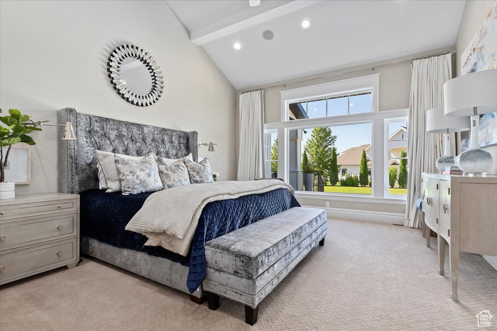 Bedroom featuring light carpet, beam ceiling, and high vaulted ceiling