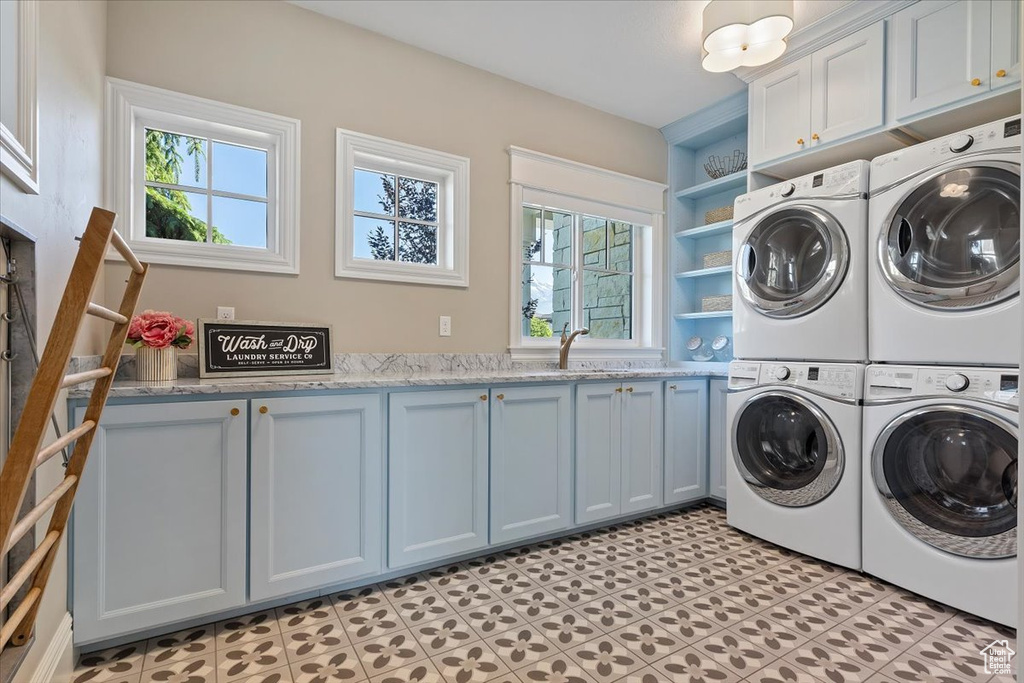 Washroom with cabinets, plenty of natural light, and light tile floors