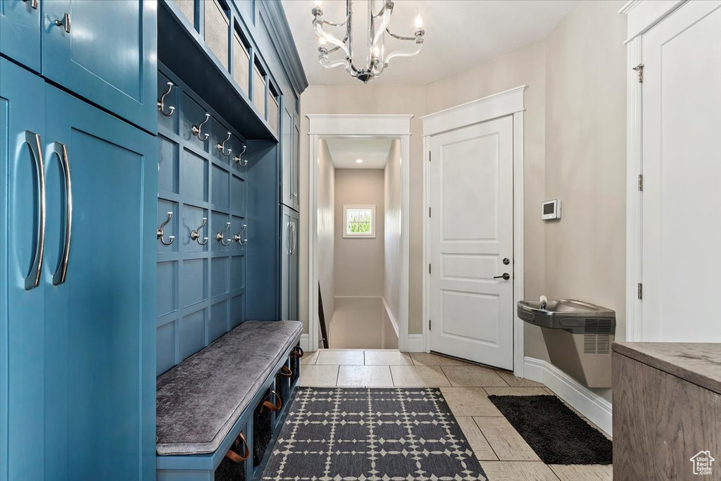 Mudroom featuring a notable chandelier and light tile floors