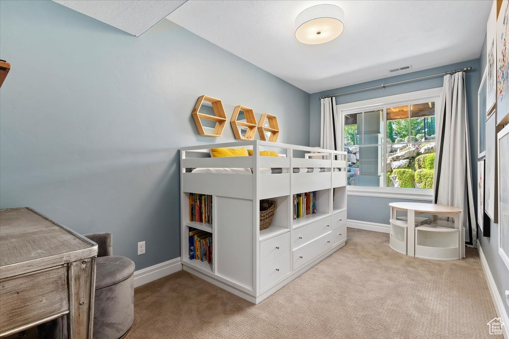 Bedroom featuring light carpet