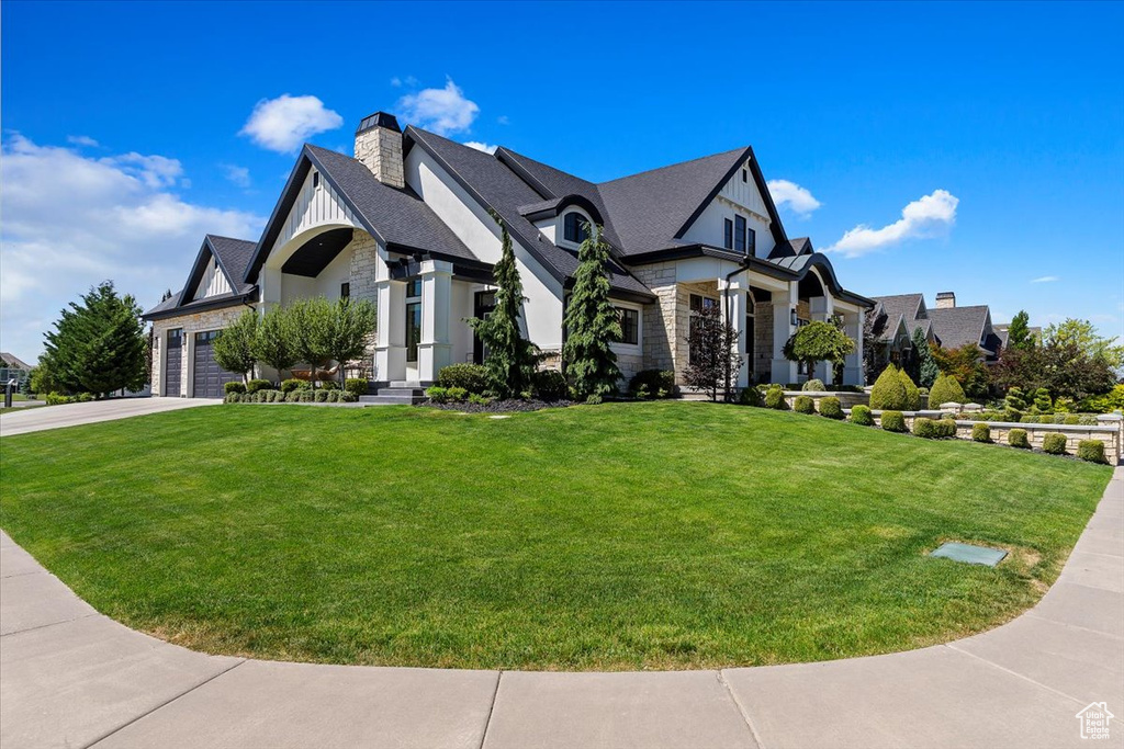 View of front of home with a front lawn and a garage