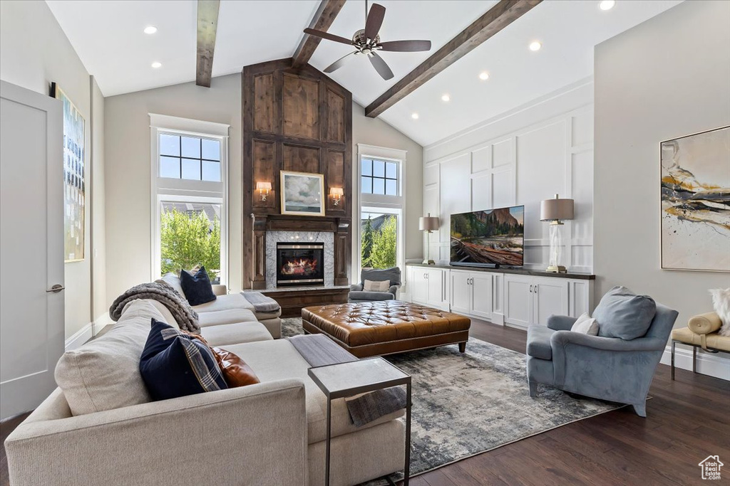 Living room featuring a large fireplace, ceiling fan, beam ceiling, high vaulted ceiling, and dark wood-type flooring