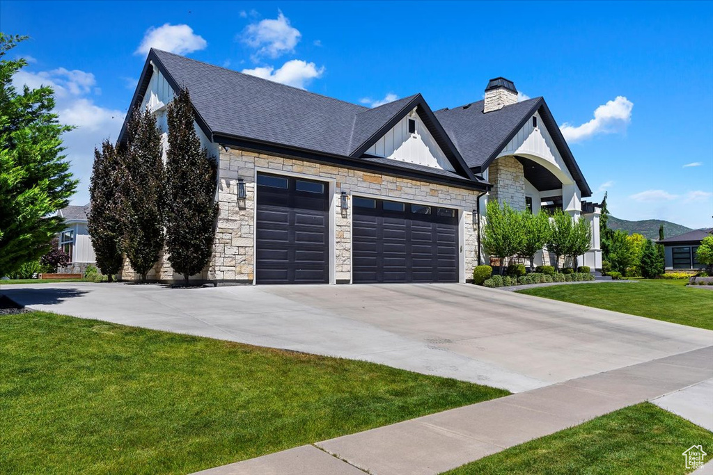 View of front facade with a garage and a front lawn