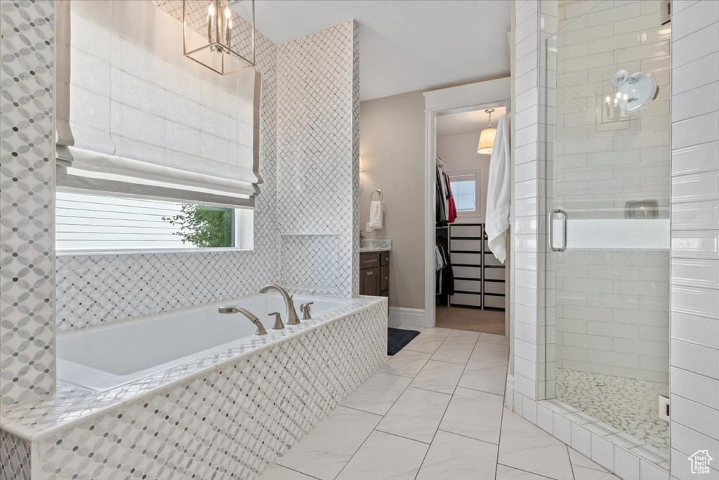 Bathroom featuring tile floors, vanity, and plus walk in shower