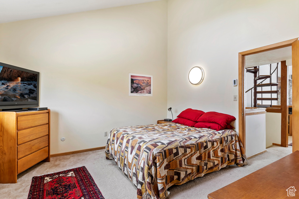 Carpeted bedroom with high vaulted ceiling