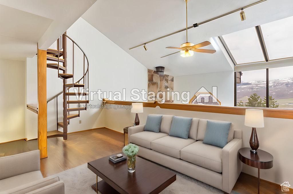 Living room featuring ceiling fan, a mountain view, hardwood / wood-style floors, track lighting, and lofted ceiling