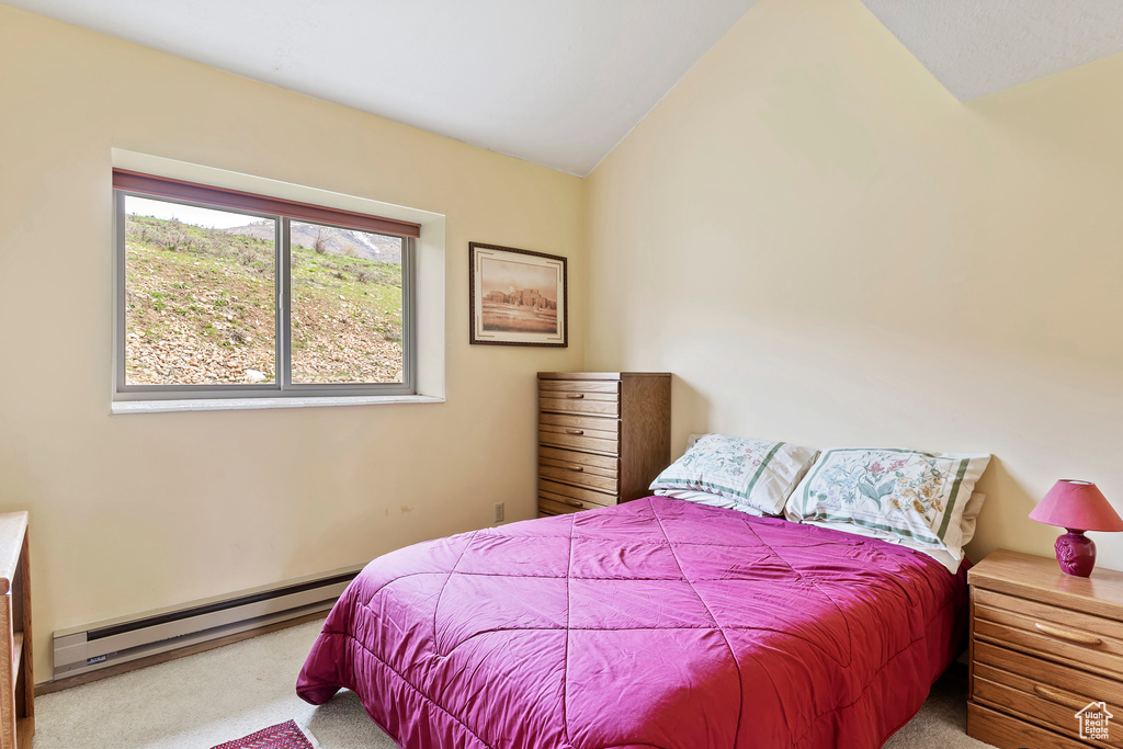 Bedroom featuring carpet flooring, baseboard heating, and lofted ceiling