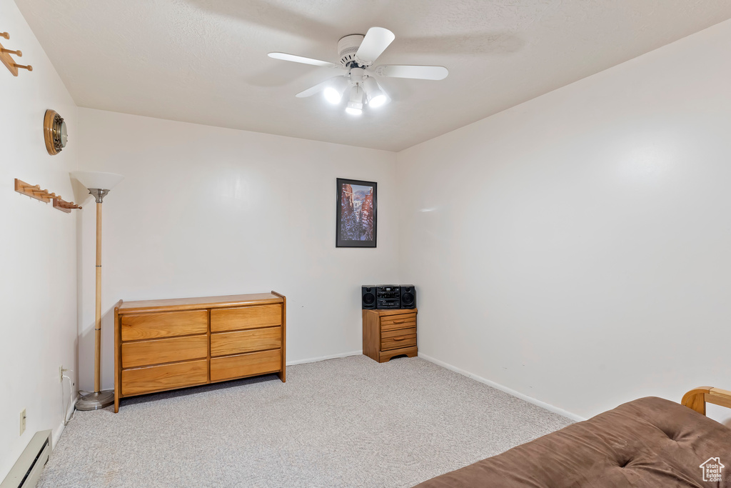 Bedroom featuring carpet flooring, baseboard heating, and ceiling fan