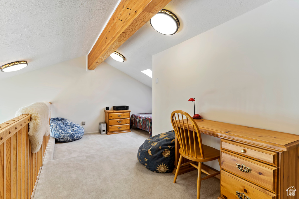 Office featuring a textured ceiling, lofted ceiling with beams, and light colored carpet