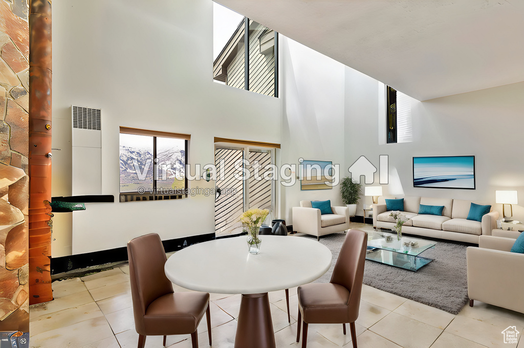 Tiled dining room with a high ceiling and a healthy amount of sunlight