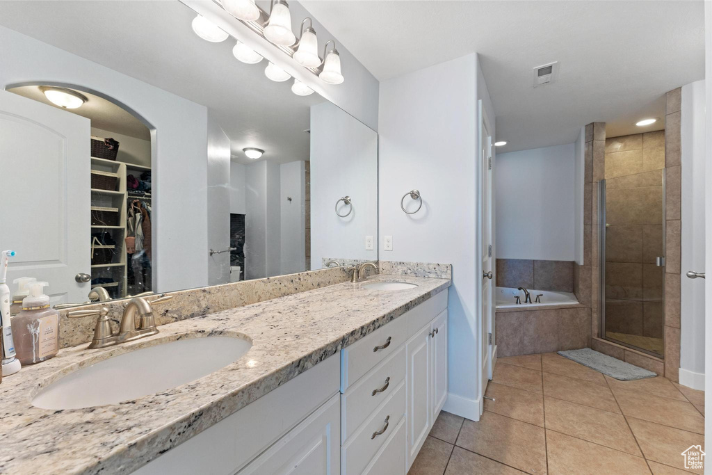 Bathroom with tile floors, large vanity, separate shower and tub, and dual sinks