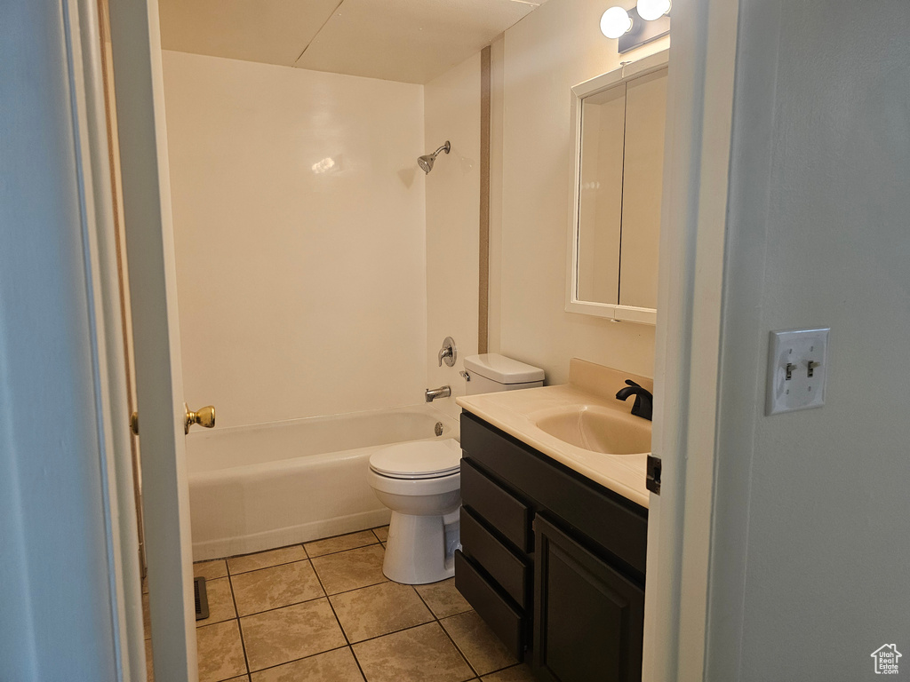 Full bathroom featuring washtub / shower combination, tile flooring, vanity, and toilet