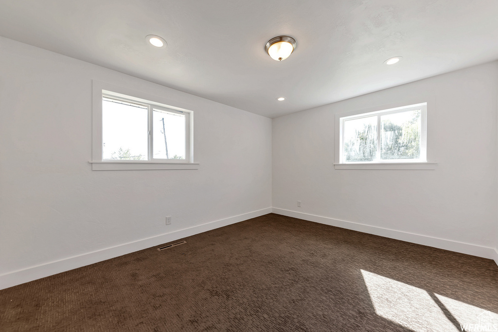 Carpeted empty room featuring plenty of natural light