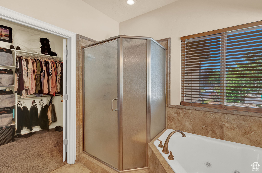 Bathroom featuring vaulted ceiling, independent shower and bath, and tile flooring