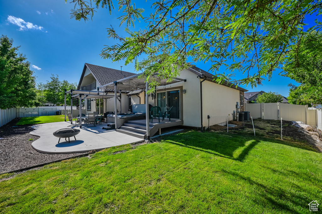 Rear view of house with a pergola, a patio area, and a lawn