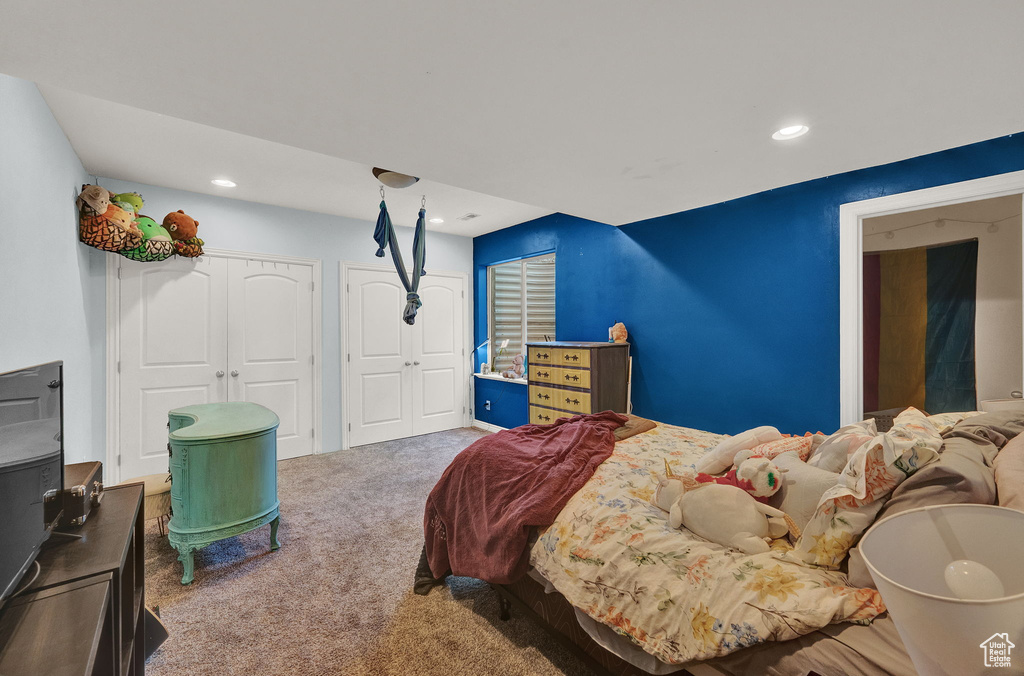 Carpeted bedroom featuring multiple closets