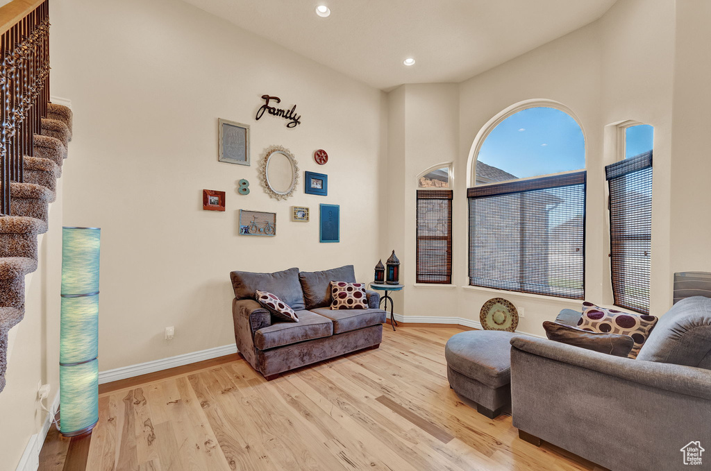 Living room with a high ceiling and hardwood / wood-style flooring