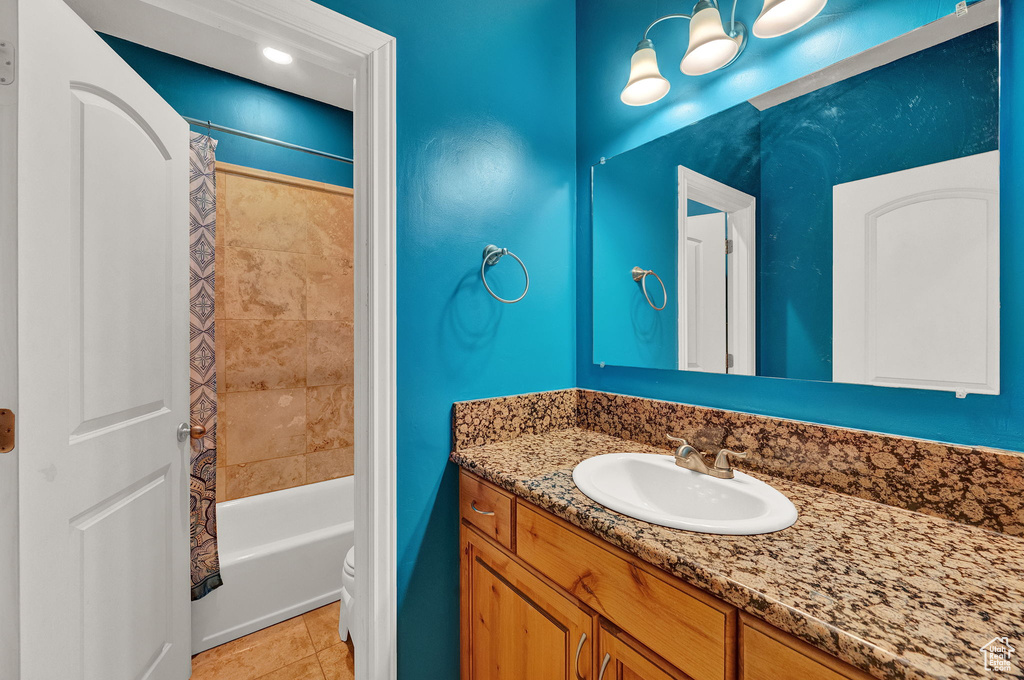 Full bathroom featuring shower / bathtub combination with curtain, tile flooring, toilet, and vanity