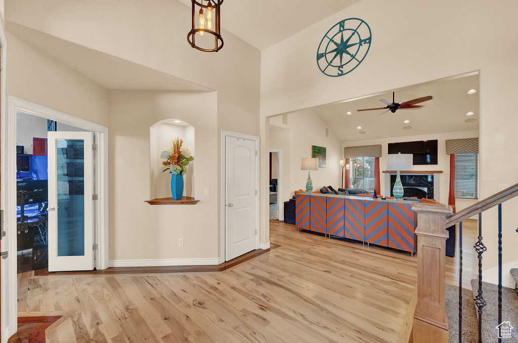 Interior space with a premium fireplace, hardwood / wood-style floors, ceiling fan, and lofted ceiling