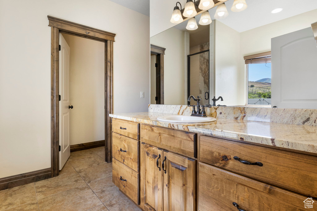 Bathroom featuring vanity with extensive cabinet space and tile floors