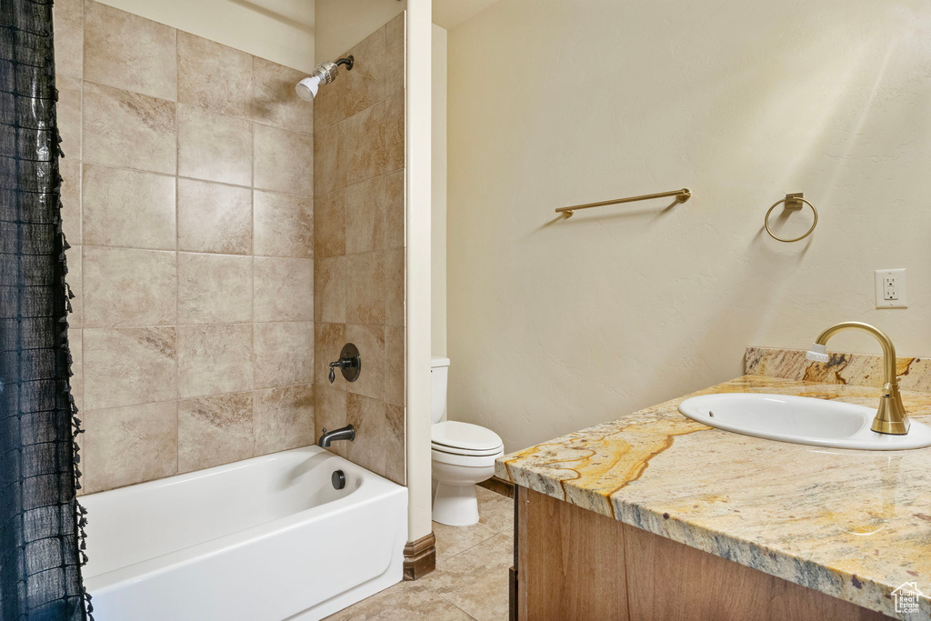 Full bathroom with vanity, toilet, tile floors, and shower / tub combo