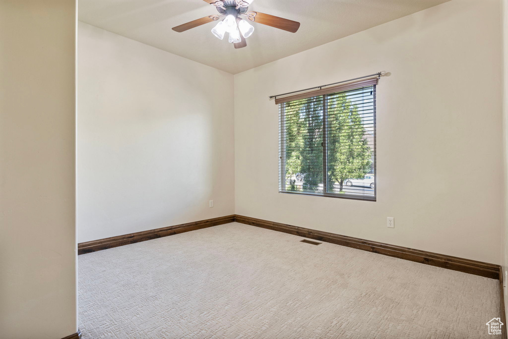 Spare room with ceiling fan and carpet flooring