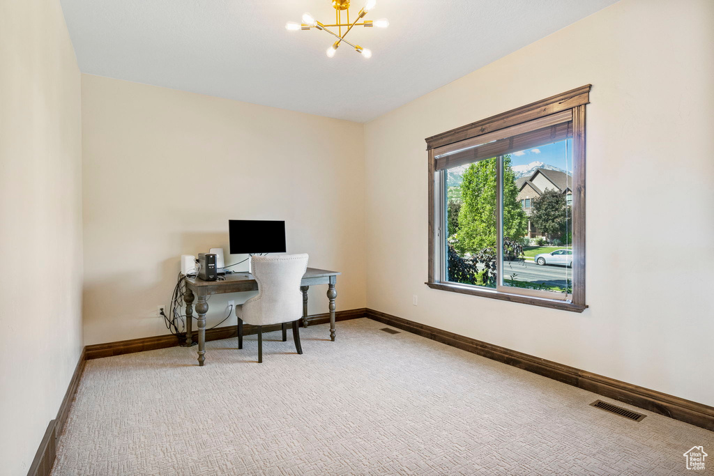 Office area featuring a notable chandelier and carpet