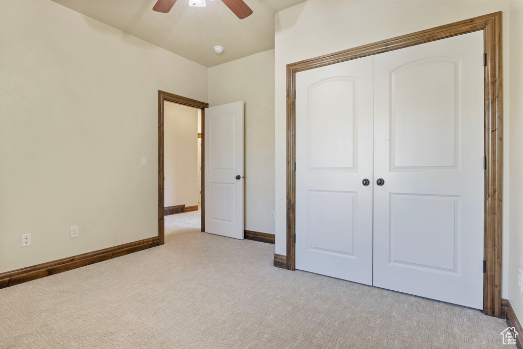 Unfurnished bedroom with light carpet, a closet, and ceiling fan