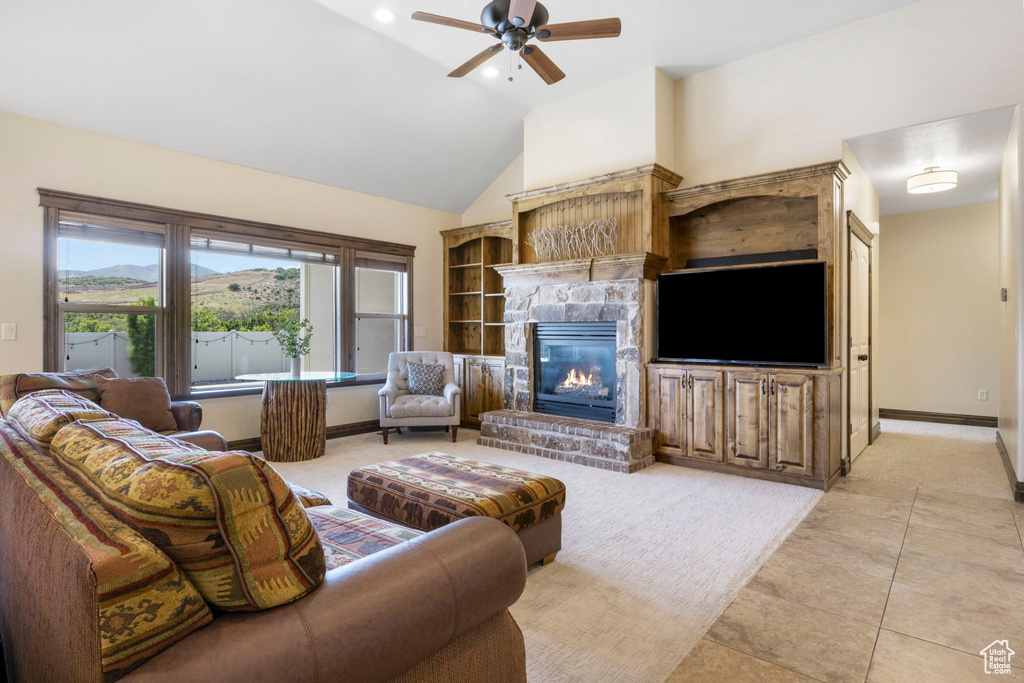 Tiled living room featuring high vaulted ceiling, ceiling fan, and a fireplace