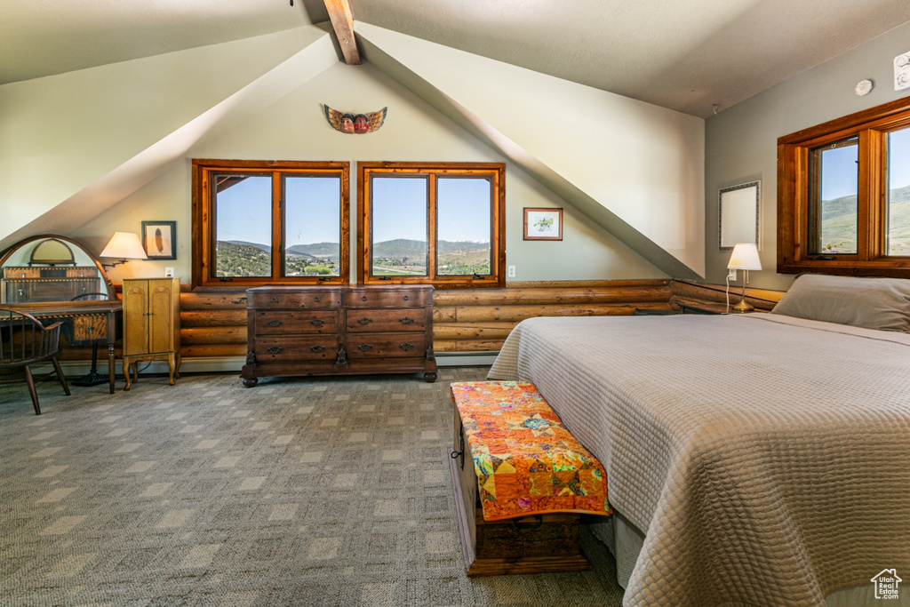 Bedroom featuring dark carpet, a baseboard radiator, lofted ceiling with beams, and multiple windows