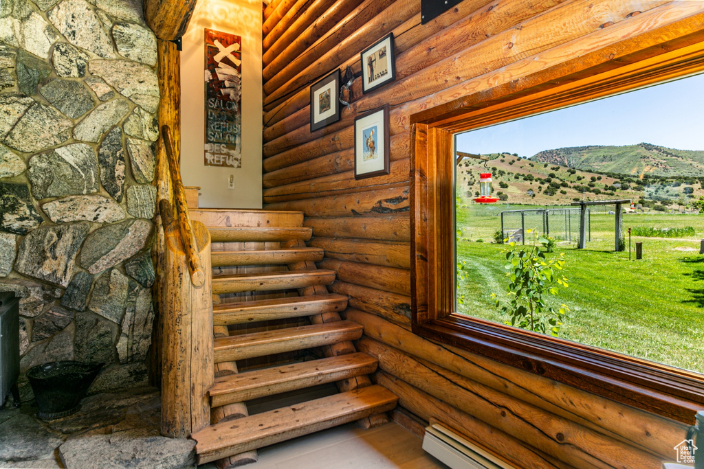 Stairway featuring a mountain view, baseboard heating, and log walls