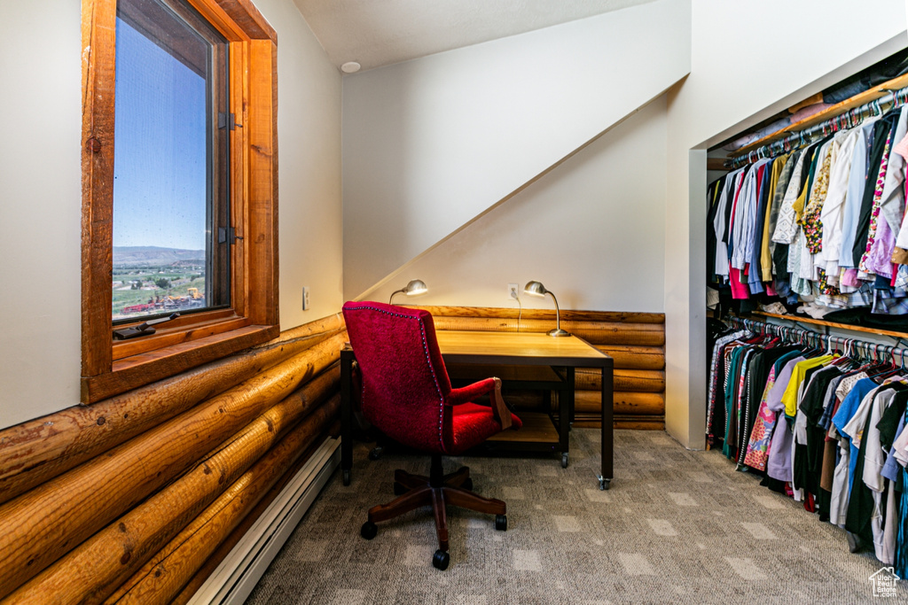 Carpeted home office with rustic walls