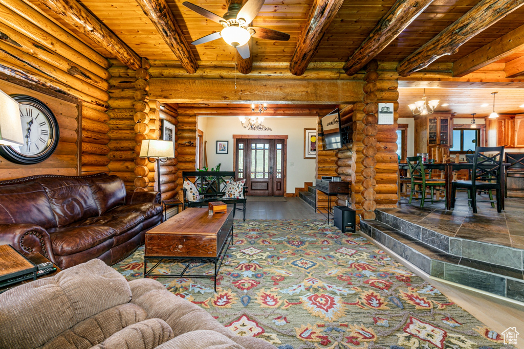 Living room featuring wooden ceiling, log walls, and beam ceiling