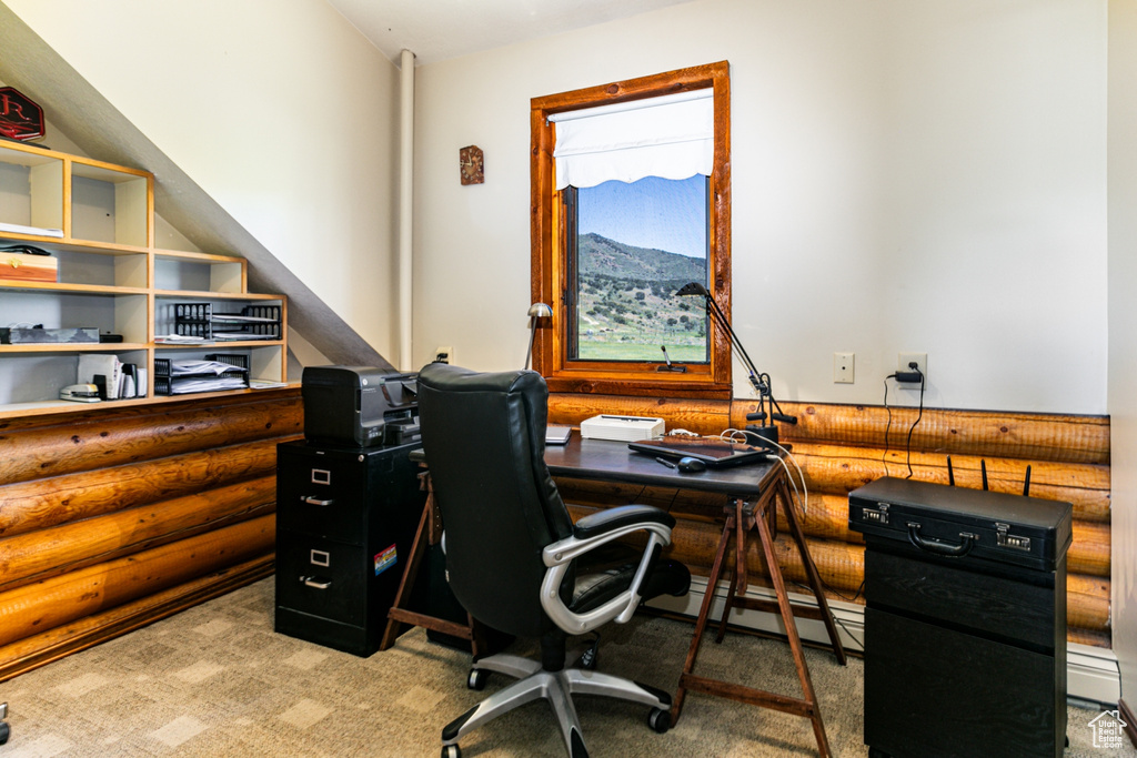 Home office with a baseboard heating unit, rustic walls, a mountain view, and light colored carpet