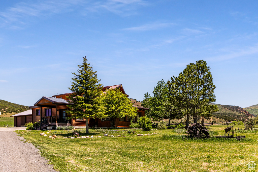 View of front of home featuring a front yard, a garage, and a mountain view