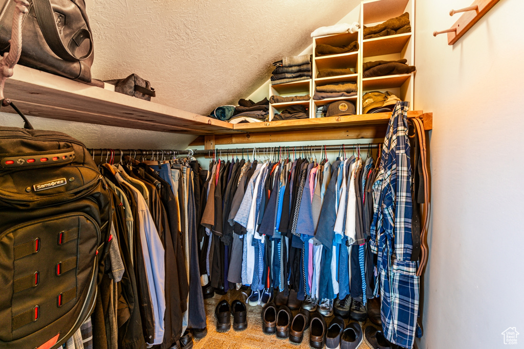 Walk in closet featuring carpet flooring and vaulted ceiling