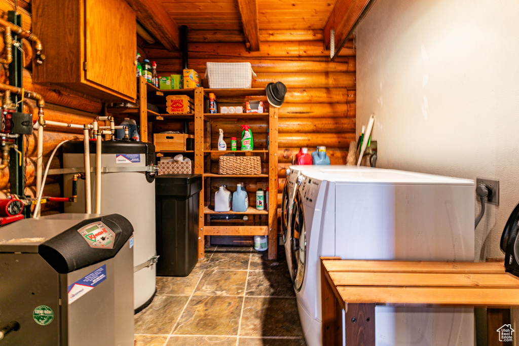 Storage area featuring water heater and washing machine and clothes dryer