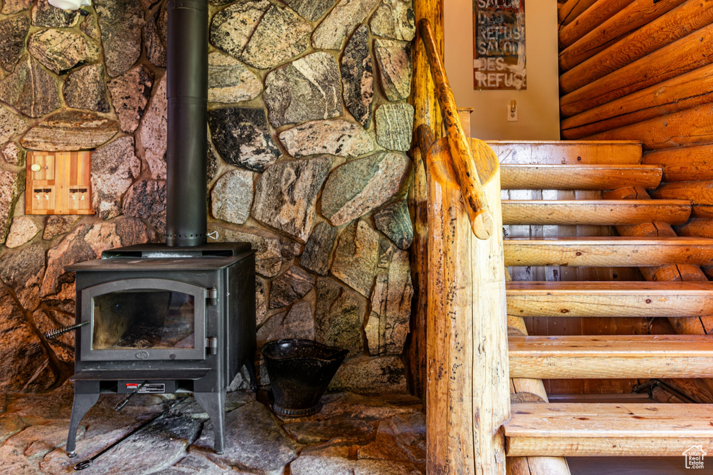 Interior details featuring log walls and a wood stove