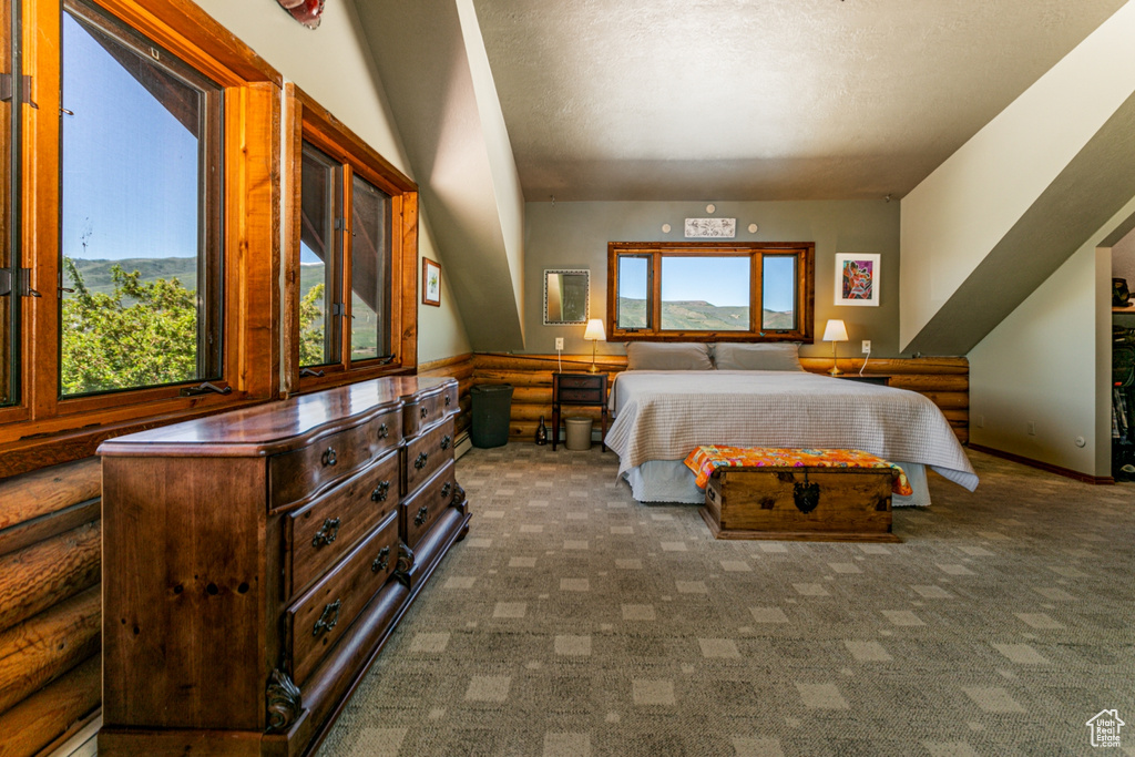 Bedroom with a textured ceiling and dark colored carpet