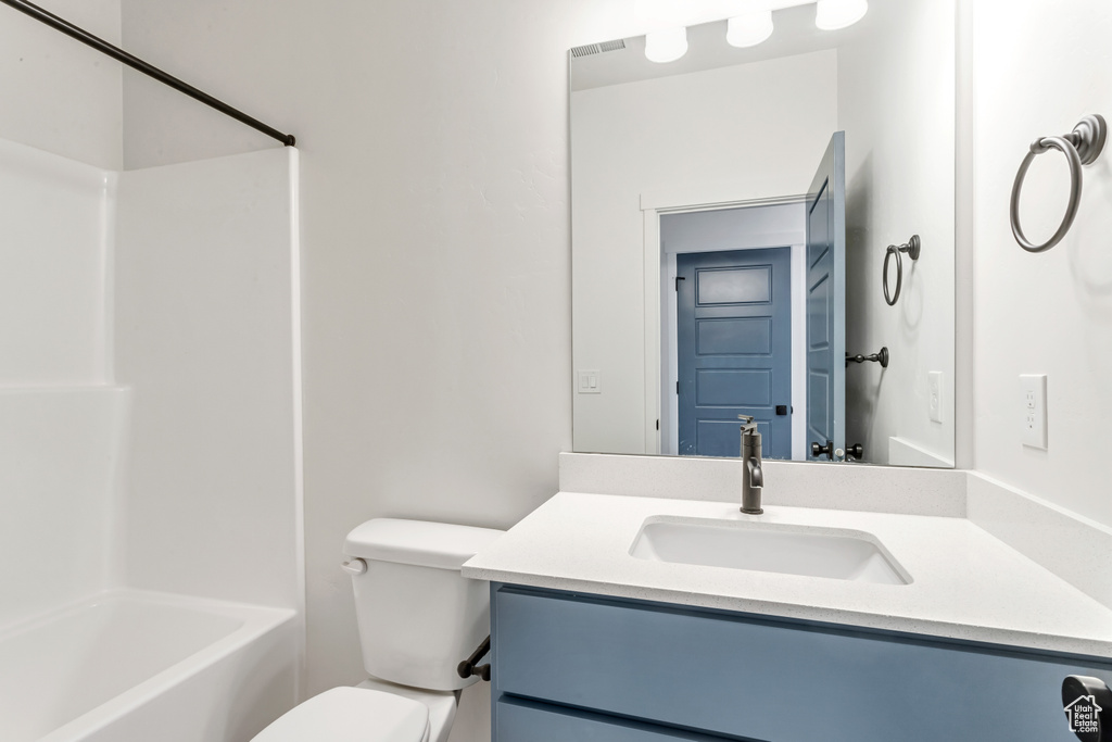 Full bathroom featuring  shower combination, vanity, and toilet