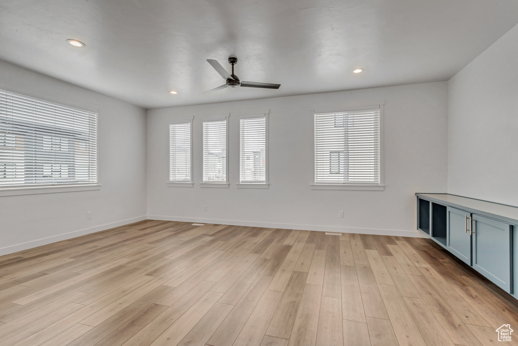 Unfurnished room with ceiling fan and light hardwood / wood-style flooring